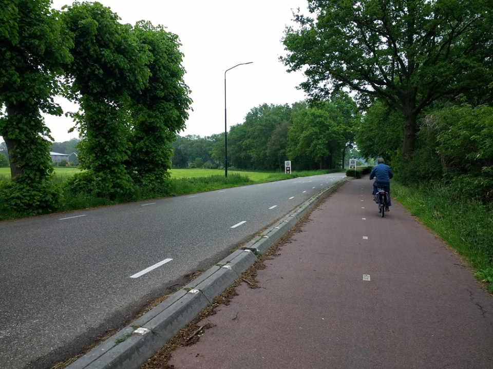 Een foto van een fietspad langs een weg.