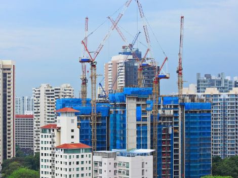 High-rise buildings with cranes around them.