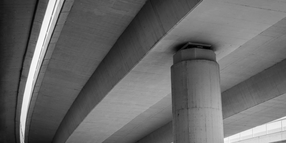 Een foto van een grote betonnen paal onder een weg.