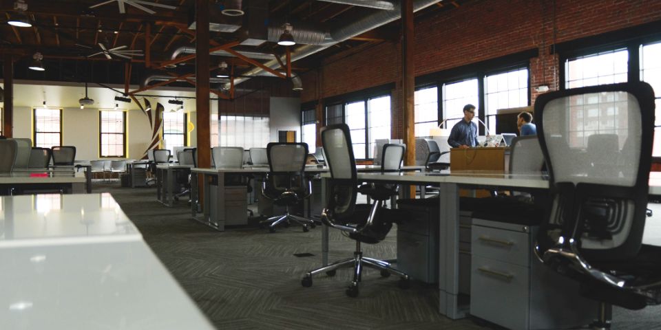 Een ruime kantoorruimte met bureaustoelen.