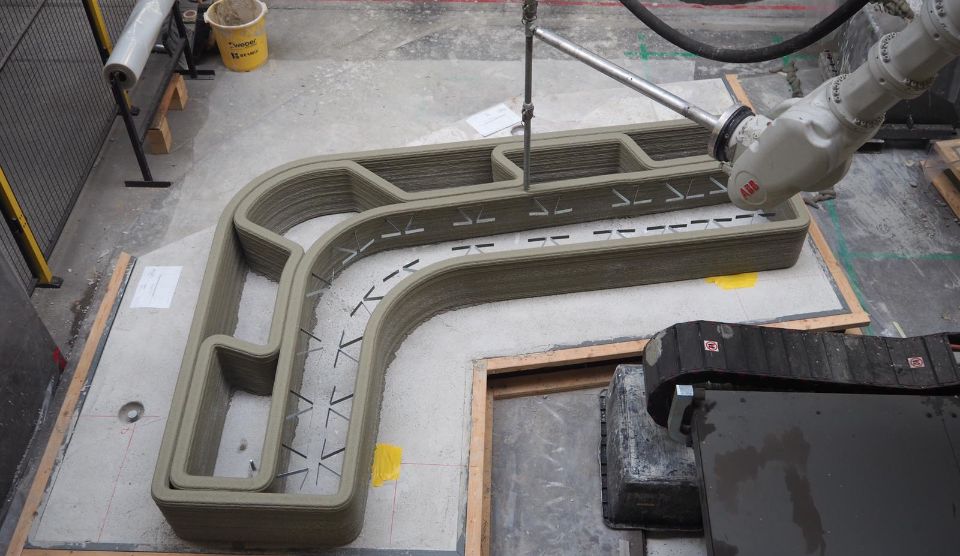 Foto van een 3D Betonprinter in een fabriek. De 3D betonprinter is bezig.
